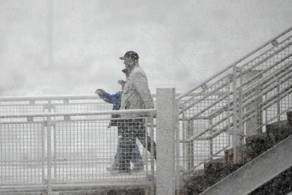 Aficionados al hockey se dirigen al Ball Arena mientras una nevada de primavera pasa por la...