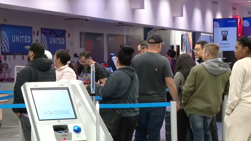 Passengers wait in line at the El Paso International Airport after all flights were grounded...