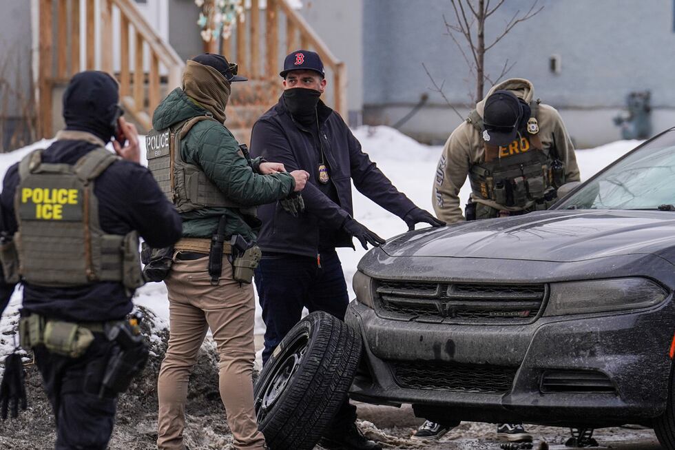 Agentes federales cambian el neumático de un vehículo durante una redada migratoria, el jueves...