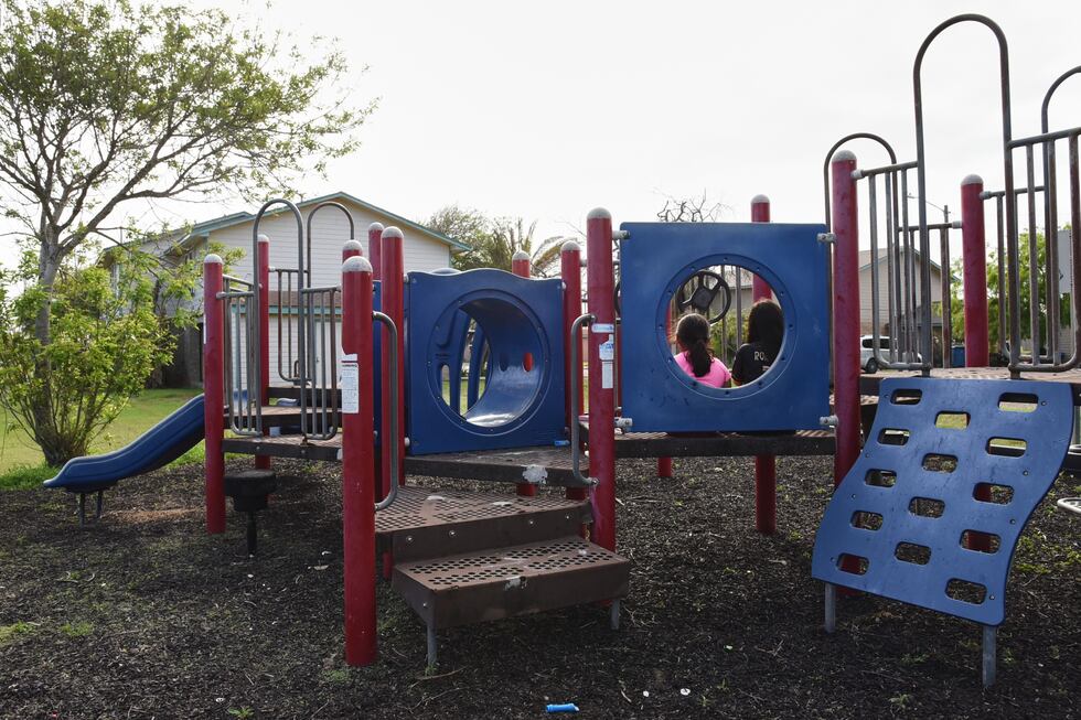 Dos hermanas juegan en un parque infantil del barrio, el cual permanece prácticamente vacío,...