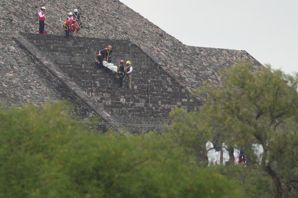 Los forenses bajan el cadáver de una víctima por una pirámide después de que, según las...